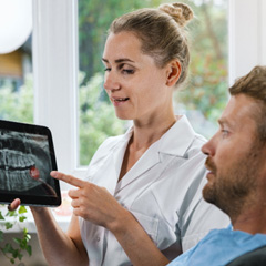 Dentist showing patient his problematic wisdom tooth on an X-ray