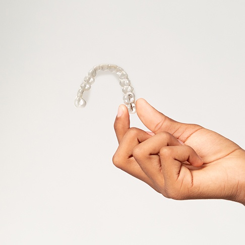 Closeup of teen holding clear aligner