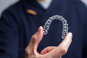 Dentist holding a single Invisalign aligner